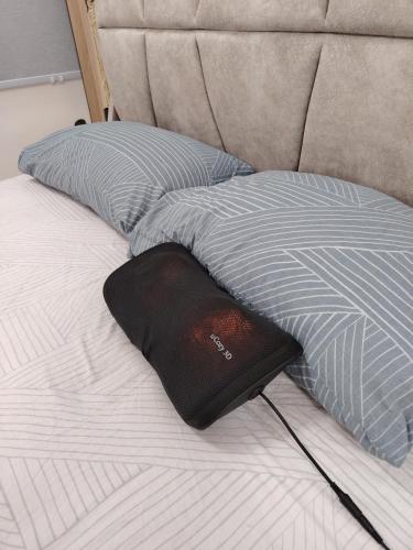 a book laying on a bed with two pillows at D Banyan Homestay, Bukit Banyan in Sungai Petani