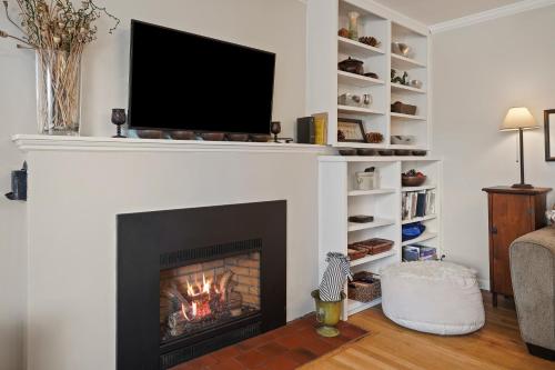 a living room with a fireplace with a tv above it at NW Nest 30 Day Minimum in Bend