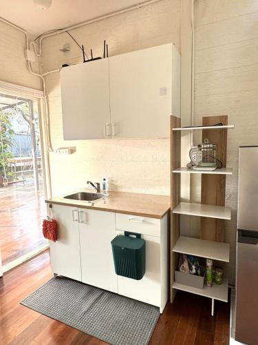 a kitchen with white cabinets and a sink at DD Canel in Bangkok