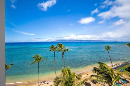 een uitzicht op een strand met palmbomen en de oceaan bij Valley Isle Resort 804 condo in Kahana