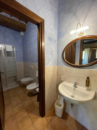 a bathroom with two sinks and a mirror at Le Calvie, country house in Camerino