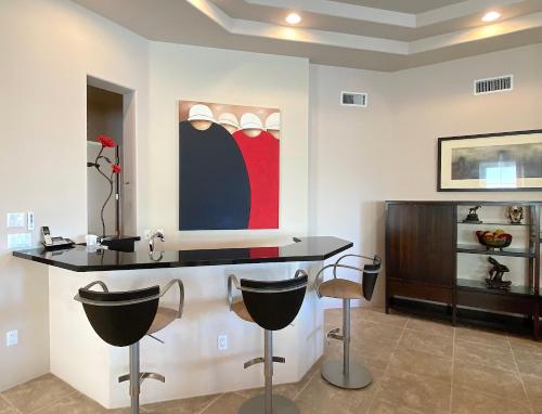 a kitchen with a black counter and stools at Double Eagle in Rancho Mirage