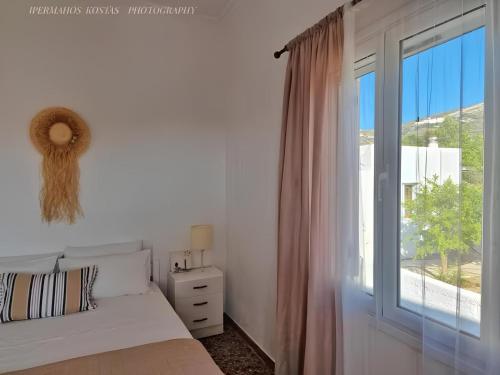 a bedroom with a bed and a large window at Michael's Home Cycladic Cottage House in Kini