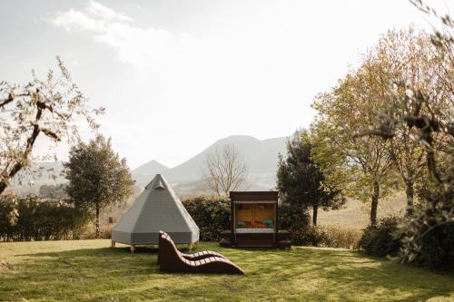 a tent and a pair of shoes in the grass at Le Calvie, country house in Camerino