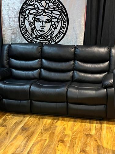 a black leather couch sitting in a room at Perfect Stay Near Glasgow Town in Glasgow