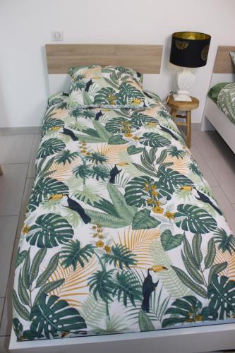 - un lit avec une couette et des oiseaux et des plantes dans l'établissement Appartement l'esprit de Lourdes, proche sanctuaire et gare, vue sur le château, à Lourdes