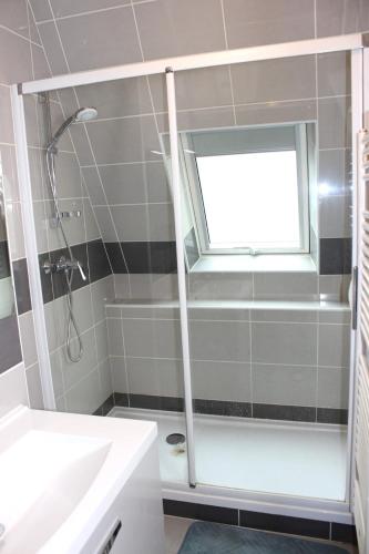 une salle de bain avec une douche et un lavabo et une fenêtre dans l'établissement Appartement l'esprit de Lourdes, proche sanctuaire et gare, vue sur le château, à Lourdes