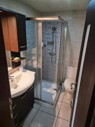 a bathroom with a shower and a sink and a toilet at Urban Chic Apartment Marsalforn in Marsalforn