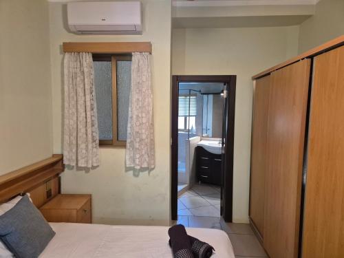 a bedroom with a bed and a door to a bathroom at Urban Chic Apartment Marsalforn in Marsalforn