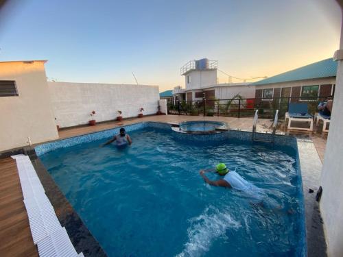 two people in a swimming pool on a building at PARAM RESORT in Mahabaleshwar