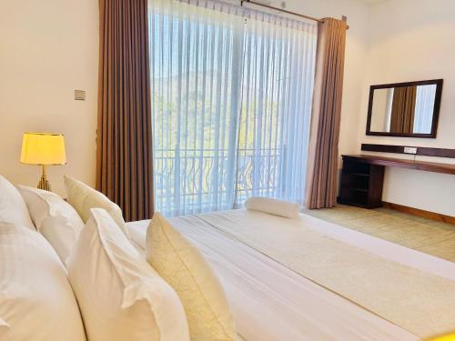 a hotel room with a large window and a bed at The Marigold Hotel in Gampola