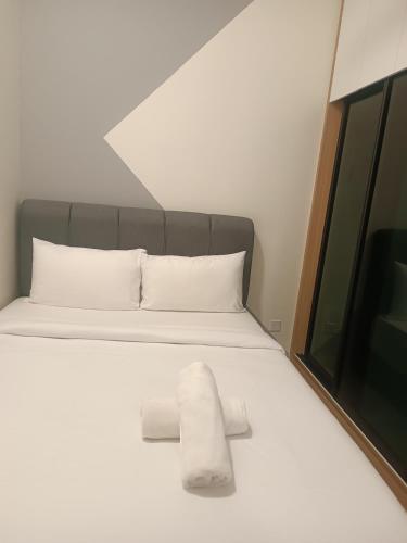 a bed with two white towels on it at Trion KL Residence by Skyline in Kuala Lumpur