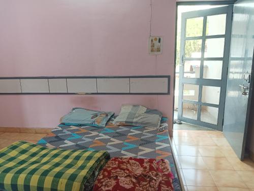a bedroom with a bed and a window and a door at New sharma homestay in Prayagraj