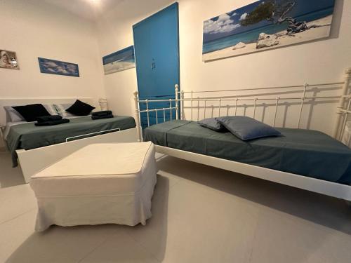 Habitación con 2 camas y reposapiés. en Casa Azzurro, en Ostuni
