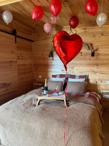 a heart balloon is hanging above a bed at Le chalet du hameau in Barbazan