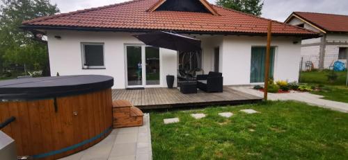 a small white house with an umbrella in the yard at Freya House Valea Avrigului in Avrig