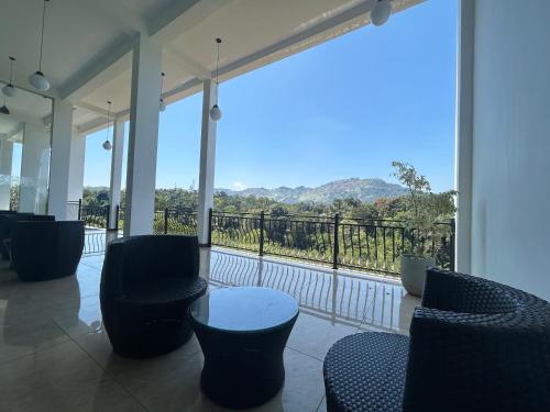 a room with chairs and a balcony with a view at The Marigold Hotel in Gampola