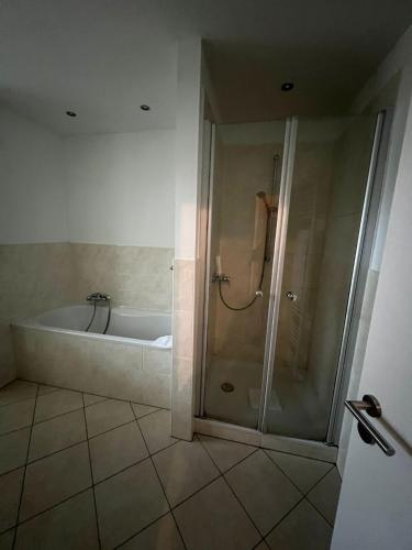 a bathroom with a shower and a bath tub at Hotel Hüttmann in Norddorf