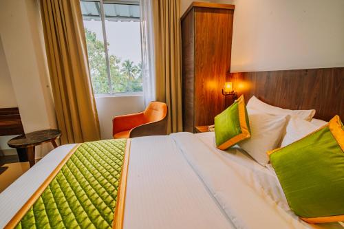 a hotel room with a bed and a window at Hotel Seven Lights in Ernakulam