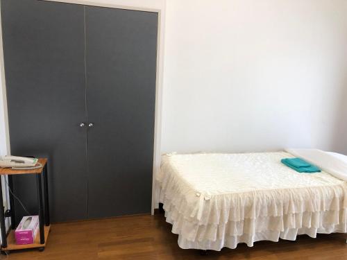 a bedroom with a bed and a black closet at Weekly Harbourview Mansion Main Building in Naha