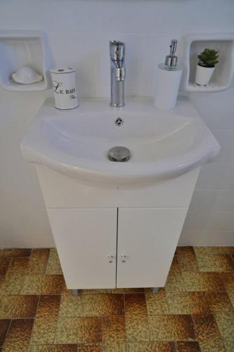 a white sink with two cups on top of it at Michael's Home Cycladic Cottage House in Kini