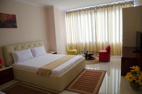 um quarto com uma cama, uma mesa e uma cadeira em Ikea Hotel em Tirana