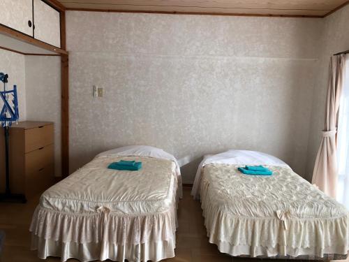 two beds sitting next to each other in a room at Weekly Harbourview Mansion Main Building in Naha
