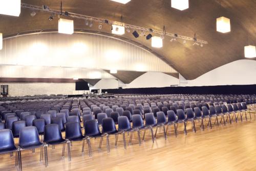 an empty lecture hall with blue chairs in it at Parkhotel Langenthal in Langenthal