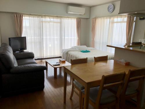 a living room with a bed and a table and a couch at Weekly Harbourview Mansion Main Building in Naha