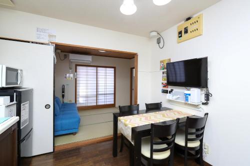 a kitchen and dining room with a table and chairs at ゲストルーム心音-金澤表参道- in Kanazawa