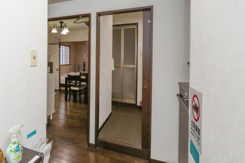 a hallway with a mirror and a dining room at ゲストルーム心音-金澤表参道- in Kanazawa