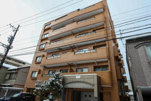 a tall brick building with an entrance in front at ゲストルーム心音-金澤表参道- in Kanazawa