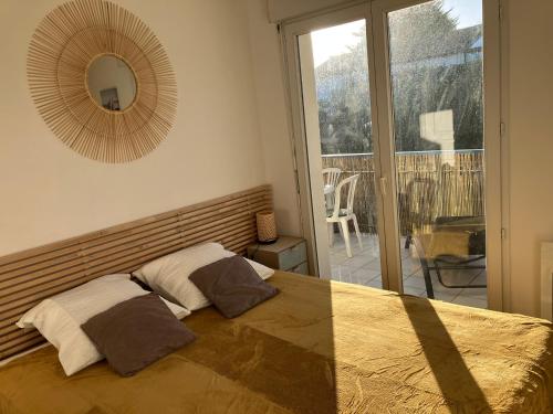 - une chambre avec un lit avec un miroir et un balcon dans l'établissement T2 Bidart La plage à pied, à Bidart