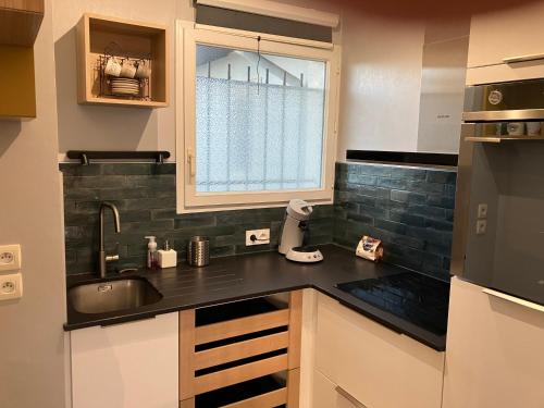 une cuisine avec un évier et une fenêtre dans l'établissement T2 Bidart La plage à pied, à Bidart