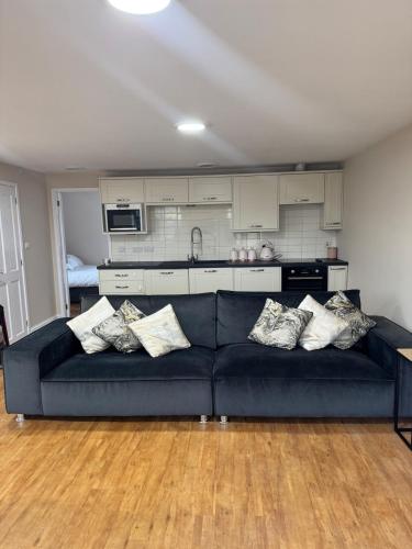 a living room with a blue couch and a kitchen at Cosy Cloud in Congleton