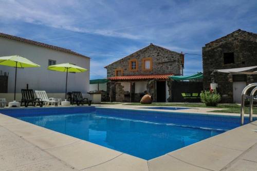 una piscina di fronte a una casa con un edificio di Monte Cimeiro a Chaveirinha