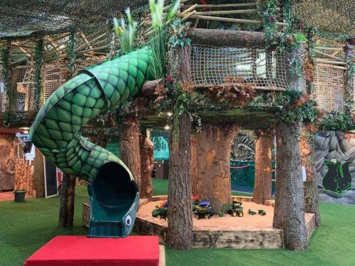 a green mermaid slide in front of a building at Cosy Cloud in Congleton