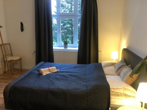 a bedroom with a bed with a doll on a blue blanket at Charming Townhouse in the Heart of Haderslev in Haderslev