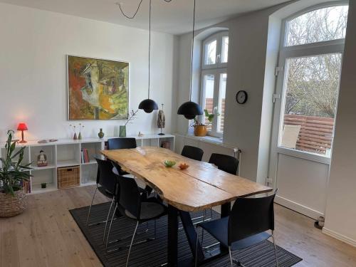 a dining room with a wooden table and chairs at Charming Townhouse in the Heart of Haderslev in Haderslev