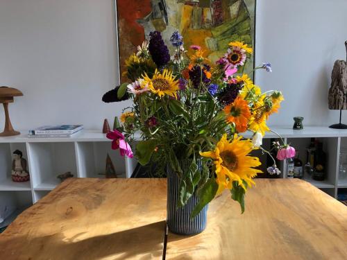 a vase of flowers sitting on top of a table at Charming Townhouse in the Heart of Haderslev in Haderslev