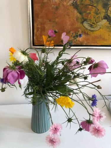 a vase filled with colorful flowers on a table at Charming Townhouse in the Heart of Haderslev in Haderslev