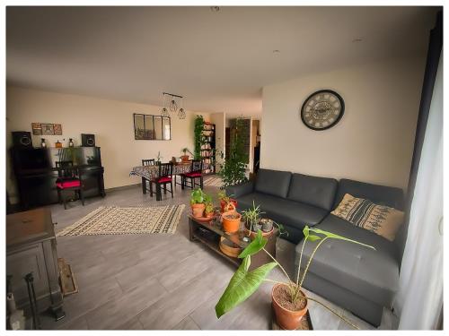 un salon avec un canapé et une horloge au mur dans l'établissement Charmante maison, à Paulhan