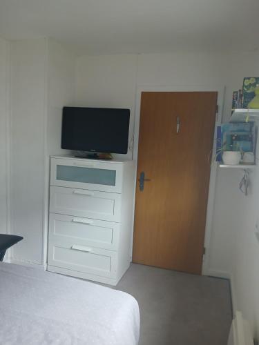 une chambre avec un lit et une télévision sur une commode dans l'établissement Lucky, à Wittenheim