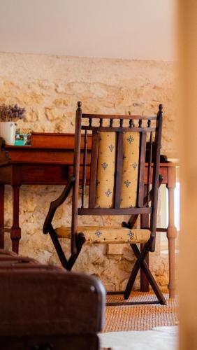 a wooden chair sitting in front of a table at Propriété Le Monneton in Sainte-Christie