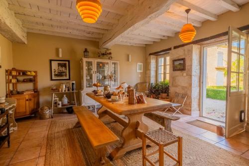 a living room with a wooden table and a large window at Propriété Le Monneton in Sainte-Christie
