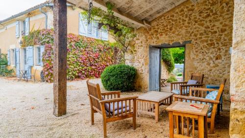 a group of wooden tables and chairs on a patio at Propriété Le Monneton in Sainte-Christie