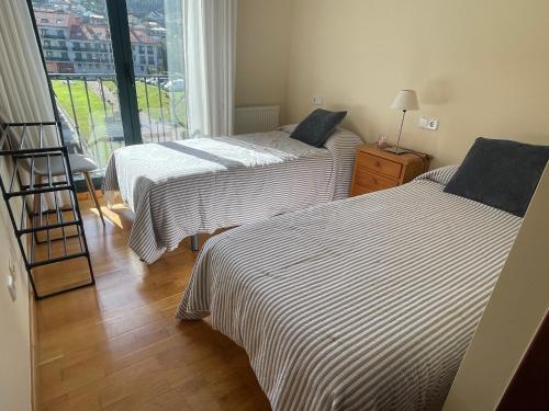 Giường trong phòng chung tại Apartamento Lúa de Baiona, cerca de la playa y el casco viejo