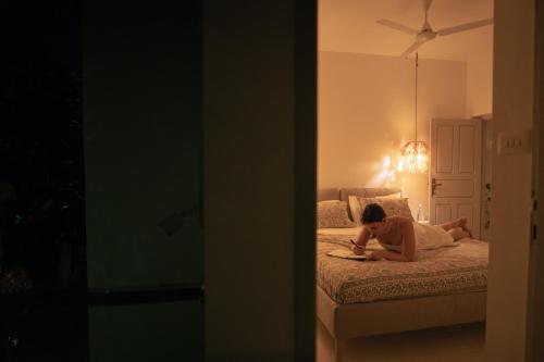a woman laying on a bed in a room at Utopia Varkala - Boutique stay in Odayam rice fields in Varkala