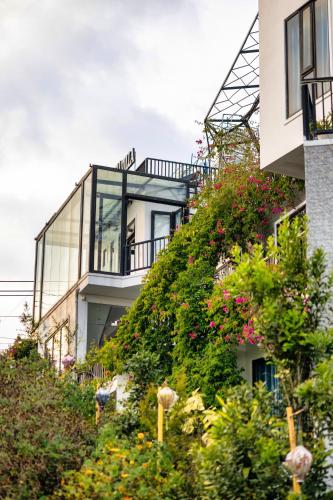 a house on a hill with flowers and plants at Be Youth Villa Đà Lạt - O'TEL in Da Lat