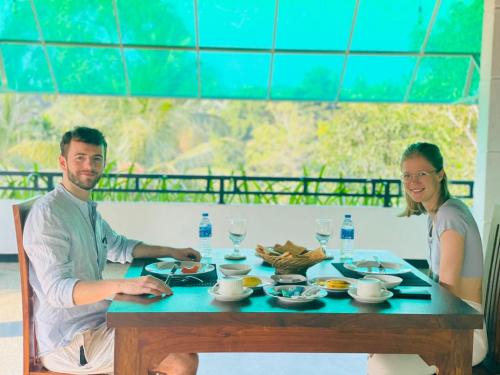 een man en vrouw aan een tafel met eten bij Tranquil Lavish Resort in Dikwella